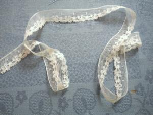 Fine dentelle ancienne, festonnée de motifs de rubans