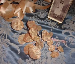 Une branche  feuilles anciennes coloris rose  fin tissu reflets" or", déco shabby,jamais utilisée