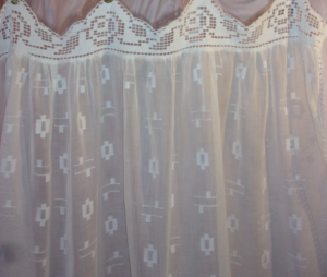 Une paire de rideaux réalisés en tissu ancien et dentelles anciennes