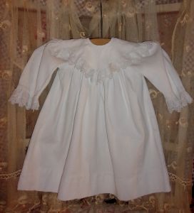 Une jolie robe ancienne d'enfant avec broderie pour poupée ou déco